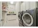 A well lit laundry room with black and white tile, a utility sink, and newer washer and dryer units at 4224 Dogwood Bend Park, Duluth, GA 30096