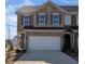 Two-story brick townhome with a two car garage, gray shutters, and well manicured landscaping at 839 Pensive Run, Dacula, GA 30019