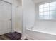 Bright bathroom features a soaking tub with tile surround and large window at 900 Cherringham Ct, Alpharetta, GA 30005