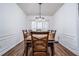 Dining room featuring wood floors, wainscoting, a modern chandelier, and large table with seating for eight at 900 Cherringham Ct, Alpharetta, GA 30005