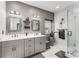 A remodeled bathroom featuring double sinks, glass shower, and gray accents at 500 Huntgate Rd, Woodstock, GA 30189