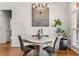 Bright dining room with hardwood floors, chandelier, large window and modern gray decor at 500 Huntgate Rd, Woodstock, GA 30189