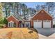 Charming brick home with a well-kept lawn and a two-car garage offers classic appeal at 500 Huntgate Rd, Woodstock, GA 30189