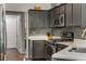 Updated kitchen with grey cabinets, quartz countertops, stainless steel appliances, and decorative mosaic tile backsplash at 500 Huntgate Rd, Woodstock, GA 30189
