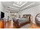 Comfortable main bedroom with tray ceiling, hardwood floors, slider doors, and decorative mirror at 500 Huntgate Rd, Woodstock, GA 30189