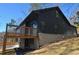 Exterior elevation showcasing stone foundation, dark siding, and wooden deck at 2078 Lyle Ave, College Park, GA 30337