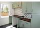 Charming kitchenette with sage green cabinets, dark countertops, and patterned backsplash at 2078 Lyle Ave, College Park, GA 30337