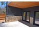 Covered patio with stone base and wood ceiling with recessed lights at 2078 Lyle Ave, College Park, GA 30337