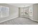 Bright bedroom features neutral paint, plush gray carpet, and multiple windows providing natural light at 4001 Oak Field Dr, Loganville, GA 30052
