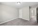 Neutrally painted bedroom with soft gray carpet, a white door, and bright trim at 4001 Oak Field Dr, Loganville, GA 30052