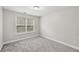 Bedroom offers a neutral palette, plush carpeting, and natural light from the window at 4001 Oak Field Dr, Loganville, GA 30052