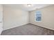 Well-lit bedroom with plush gray carpet, white trim, and a large window at 4001 Oak Field Dr, Loganville, GA 30052