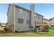 Back exterior of a two-story home with a chimney, windows, and a small deck at 4001 Oak Field Dr, Loganville, GA 30052