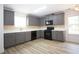 Well-equipped kitchen features gray cabinets, stainless steel appliances, and light wood flooring at 4001 Oak Field Dr, Loganville, GA 30052