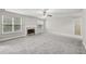 Cozy living room with a fireplace, large windows, and a ceiling fan at 4001 Oak Field Dr, Loganville, GA 30052