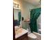Bathroom area featuring vanity, mirror, toilet and shower with green curtain at 1040 Rolling Green Dr, Acworth, GA 30102