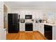 Traditional style kitchen with black appliances, white cabinetry, and hardwood floors at 2135 Primrose Place Ln, Lawrenceville, GA 30044