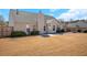 Exterior backyard featuring neutral siding, trimmed hedges, a patio, and a large brown lawn at 2450 Cordillo Ne Dr, Dacula, GA 30019