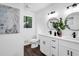 Modern bathroom featuring a double vanity with black fixtures, updated lighting and wood look floors at 2512 Hidden Hills Dr, Marietta, GA 30066
