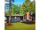 Charming single-Gathering home with gray siding, stone accents, modern chimney, and inviting front yard at 2512 Hidden Hills Dr, Marietta, GA 30066