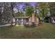 Charming home with stone accents, newly landscaped front yard, and inviting wooden front porch, at dusk at 2512 Hidden Hills Dr, Marietta, GA 30066