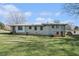 Spacious backyard with lots of grass, mature trees, and a view of the rear exterior of the home at 803 Denise Sw Ct, Stone Mountain, GA 30087