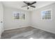 Bright bedroom featuring gray wood floors, a ceiling fan, and well-lit double windows at 803 Denise Sw Ct, Stone Mountain, GA 30087