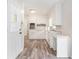 Bright kitchen featuring white cabinets, stainless steel oven, hard surface counter and luxury vinyl flooring at 803 Denise Sw Ct, Stone Mountain, GA 30087