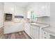 Kitchen featuring white cabinets, stainless steel appliances, and updated flooring at 803 Denise Sw Ct, Stone Mountain, GA 30087