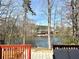 Relaxing backyard view with a deck overlooking a peaceful lake, surrounded by mature trees at 3179 Dunlin Lake Rd, Lawrenceville, GA 30044