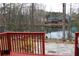 A view from the red deck overlooking a calm lake and a patio area in the backyard at 3179 Dunlin Lake Rd, Lawrenceville, GA 30044