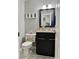 Cozy bathroom with granite countertop, dark cabinetry, decorated toilet, and framed mirror at 3179 Dunlin Lake Rd, Lawrenceville, GA 30044