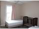 Cozy bedroom featuring a large window, neutral walls, and a simple ceiling fan for comfort at 3179 Dunlin Lake Rd, Lawrenceville, GA 30044