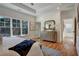 Main bedroom featuring tray ceiling, a king bed, dresser, and a view of the surrounding trees at 2159 James Aly, Atlanta, GA 30345