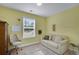 Sunny bedroom with a large window, cozy sofa, and plush carpet at 541 Glen Abbey Se Cir, Mableton, GA 30126