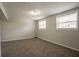 Finished basement area featuring neutral walls, wall trim, carpet, and two windows providing natural light at 5415 Tracey Dr, Stone Mountain, GA 30088