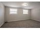 Finished basement area featuring neutral walls, wall trim, carpet, and two windows providing natural light at 5415 Tracey Dr, Stone Mountain, GA 30088