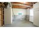 Unfinished basement area with a concrete floor, exposed beams, and a utility door at 5415 Tracey Dr, Stone Mountain, GA 30088