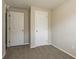 Bright bedroom featuring neutral walls and carpet with two white paneled doors at 5415 Tracey Dr, Stone Mountain, GA 30088