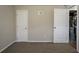 Bedroom features neutral paint, carpet, and two white doors, one to a closet with mechanicals at 5415 Tracey Dr, Stone Mountain, GA 30088