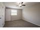 Bedroom with a ceiling fan, neutral carpet, and a window letting in natural light at 5415 Tracey Dr, Stone Mountain, GA 30088