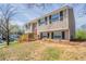 Charming two-story home with tan siding, black shutters, a red front door, and a wooden porch and rails at 5415 Tracey Dr, Stone Mountain, GA 30088