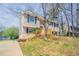 Charming two-story home with tan siding, black shutters, a red front door, and a wooden porch and rails at 5415 Tracey Dr, Stone Mountain, GA 30088