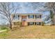 Charming two-story home with tan siding, black shutters, a red front door, and a wooden porch and rails at 5415 Tracey Dr, Stone Mountain, GA 30088