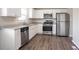 Updated kitchen featuring stainless steel appliances, white cabinetry, granite countertops, and wood-look flooring at 5415 Tracey Dr, Stone Mountain, GA 30088