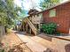 Brick apartment building showcasing wooden stairs with a sidewalk and green foliage to the side at 208 Doane St, Atlanta, GA 30315