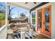 Inviting balcony with chairs, decorative pillows, outdoor rug and a pair of bright orange french doors at 431 Clifton Ne Rd, Atlanta, GA 30307