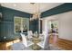 Stylish dining room features statement chandelier, wainscoting, and hardwood floors, open to a home office at 431 Clifton Ne Rd, Atlanta, GA 30307