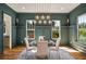 Elegant dining room features wainscoting, modern chandelier, hardwood floors, and a glass table at 431 Clifton Ne Rd, Atlanta, GA 30307