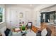 Well-lit home office featuring hardwood floors, neutral colors, a glass desk, and an open doorway to the dining room at 431 Clifton Ne Rd, Atlanta, GA 30307
